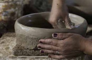 mãos de mulher fazendo panela de barro
