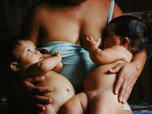 Belem, Brazil --- Original caption: A mother in Belem, Brazil nurses her twins. Mother's milk, full of antibodies, gives babies a healthy start, yet for years women in developing countries were encourage to use formula powder mixed with water. Result: Children suffered more waterborne illnesses and missed out on natural antibodies in breast milk. --- Image by © Karen Kasmauski/Science Faction/Corbis