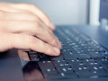 Hand over keyboard of the laptop in server room
