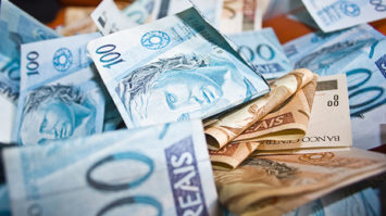 #pracegover: foto mostra notas de R$ 100 e R$ 50 dobradas
