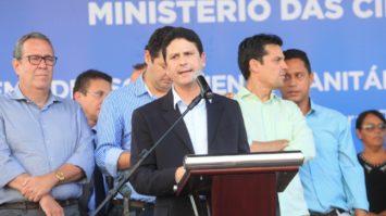 #pracegover: foto mostra ministro Bruno Araújo falando o púlpito cercado de pessoas durante cerimônia do Ministério das Cidades