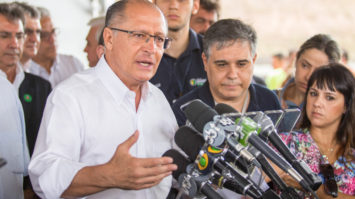 #pracegover: foto mostra governador de São Paulo, Geraldo Alckmin, falando de frente a um púlpito cheio de microfones. Tucano está de camisa social branca, rodeado por pessoas