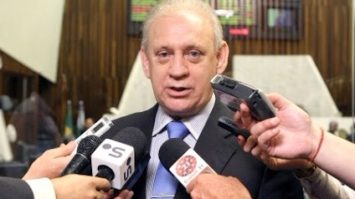 #pracegover: foto do deputado estadual Ademar Traiano envolto com microfones em entrevista