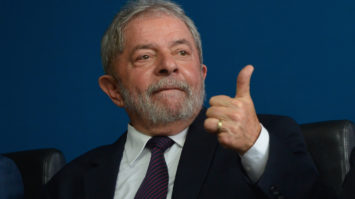#pracegover: Foto mostra o ex-presidente Lula fazendo sinal de legal na mão esquerda