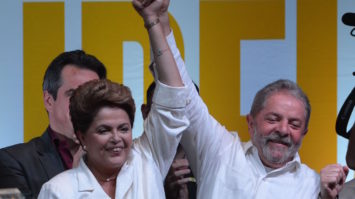 #pracegover: Dilma e Lula estão vestido de camisa branca com as mãos dadas para cima em sinal de vitória