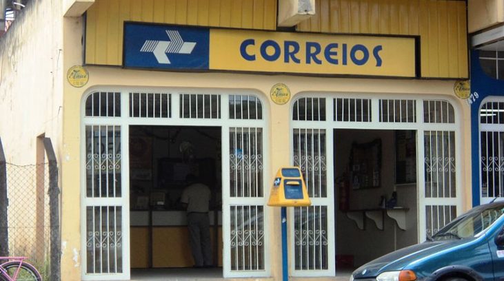 #pracegover: foto mostra fachada de agência dos Correios e um carro estacionado na frente