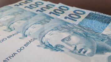 #pracegover: foto mostra cinco cédulas de R$ 100 empilhadas