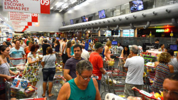#pracegover: foto ampla mostra supermercado lotado e com filas nos caixas