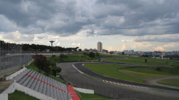 #pracegover: foto mostra parte de uma curva da pista de Interlagos em SP com arquibancada e alambrado